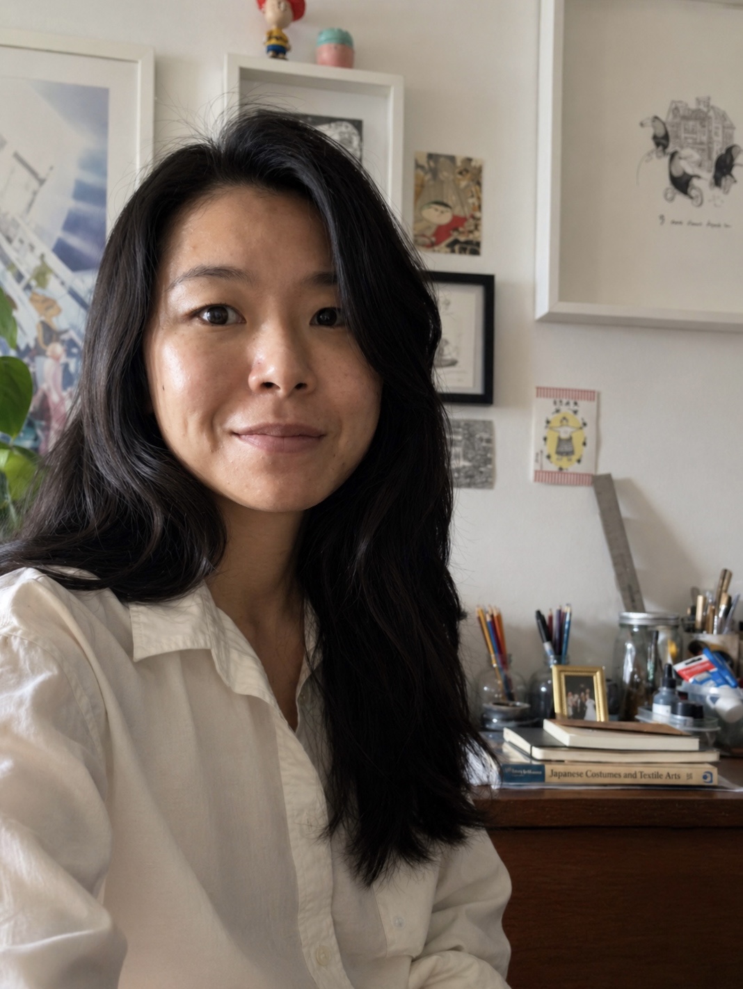Regina at her studio desk with brushes and floor plans